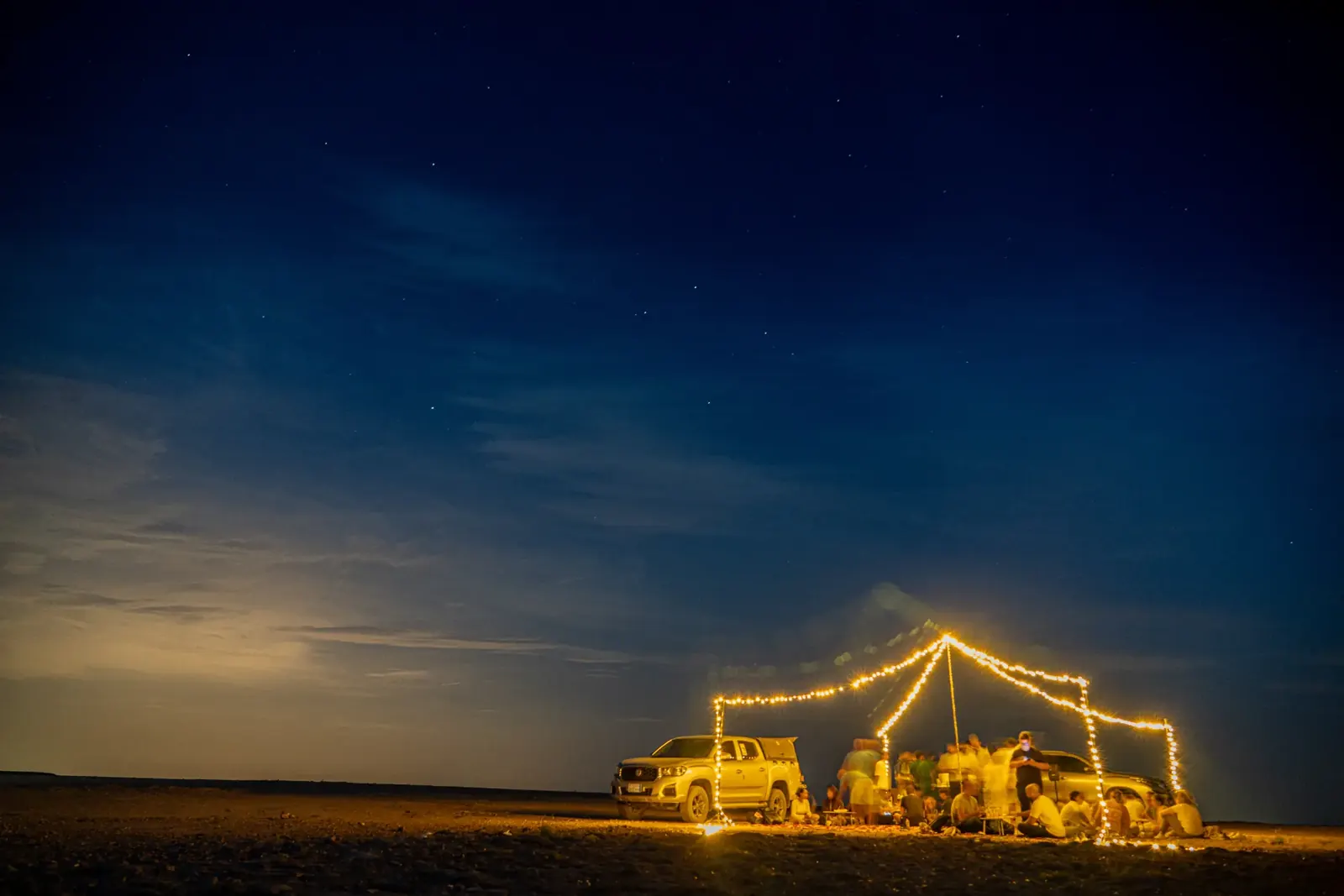 Lit desert camp under the night sky on an overnight desert safari in Dubai